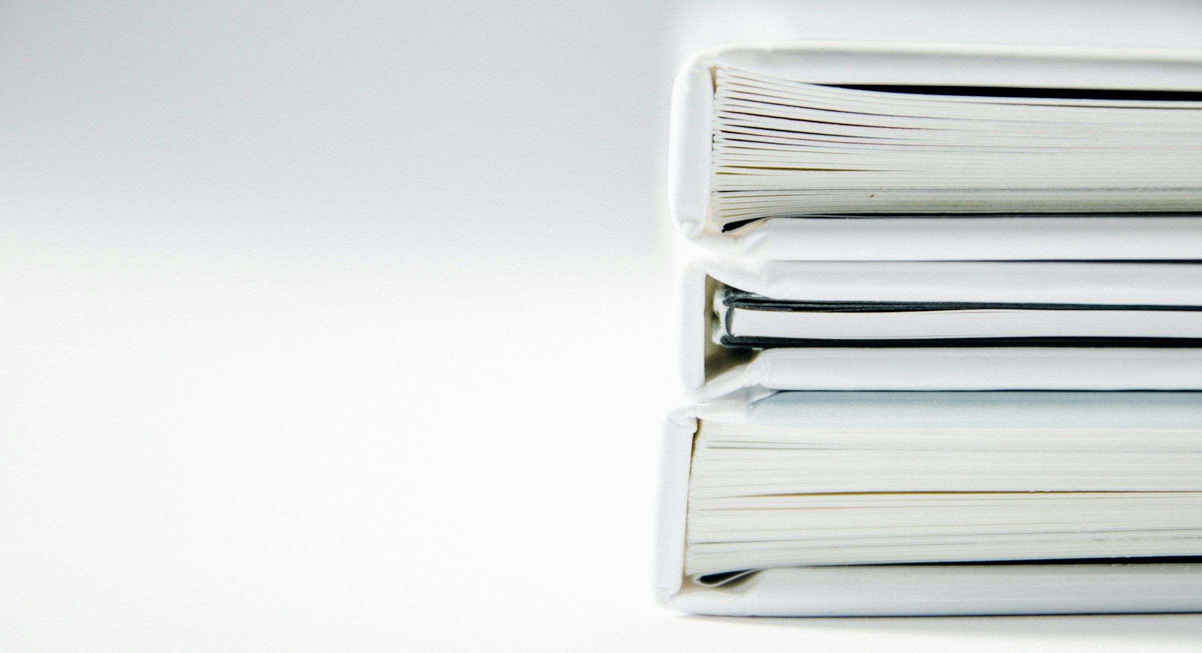 Une pile de classeurs blancs bien rangés.
